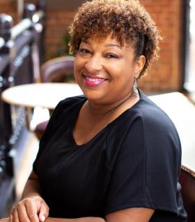 headshot of romona williams in a black blouse