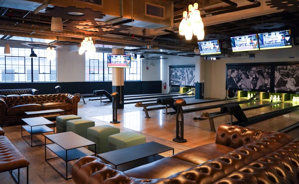 Boutique bowling alley with leather sofas and bowling pin chandeliers 