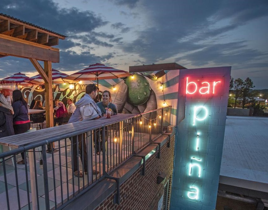 A couple having drinks at Bar Piña rooftop bar in Winston-Salem