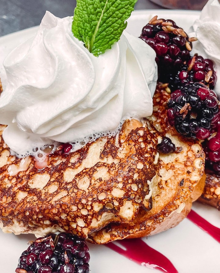 A stack of pancakes with berries and whipped cream at Young Cardinal Cafe in Winston Salem