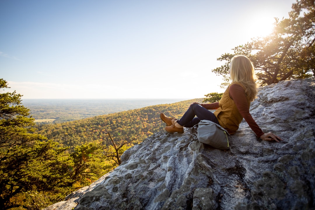 A woman sitting on an overlook at Hanging Rock State Park