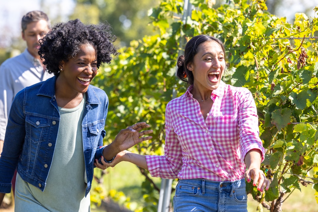 Two women exploring the vines at Jolo Winery & Vineyards.