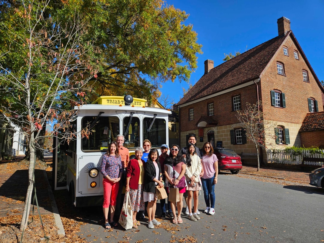 A tour group poses in front of their trolley at Old Salem Museums & Gardens.