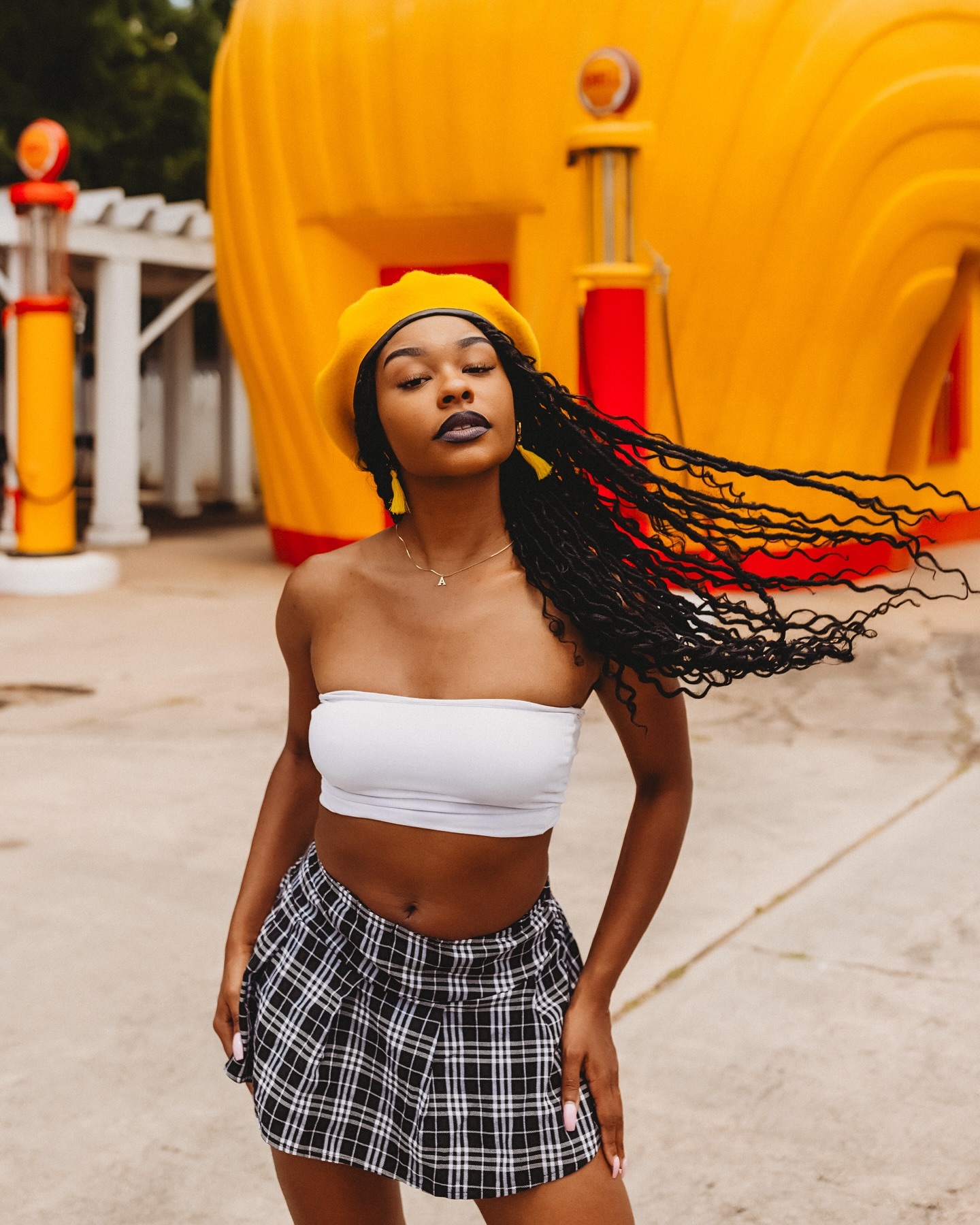 A woman poses in front of the Historic Clamshell shaped Gas Station in Winston-Salem.