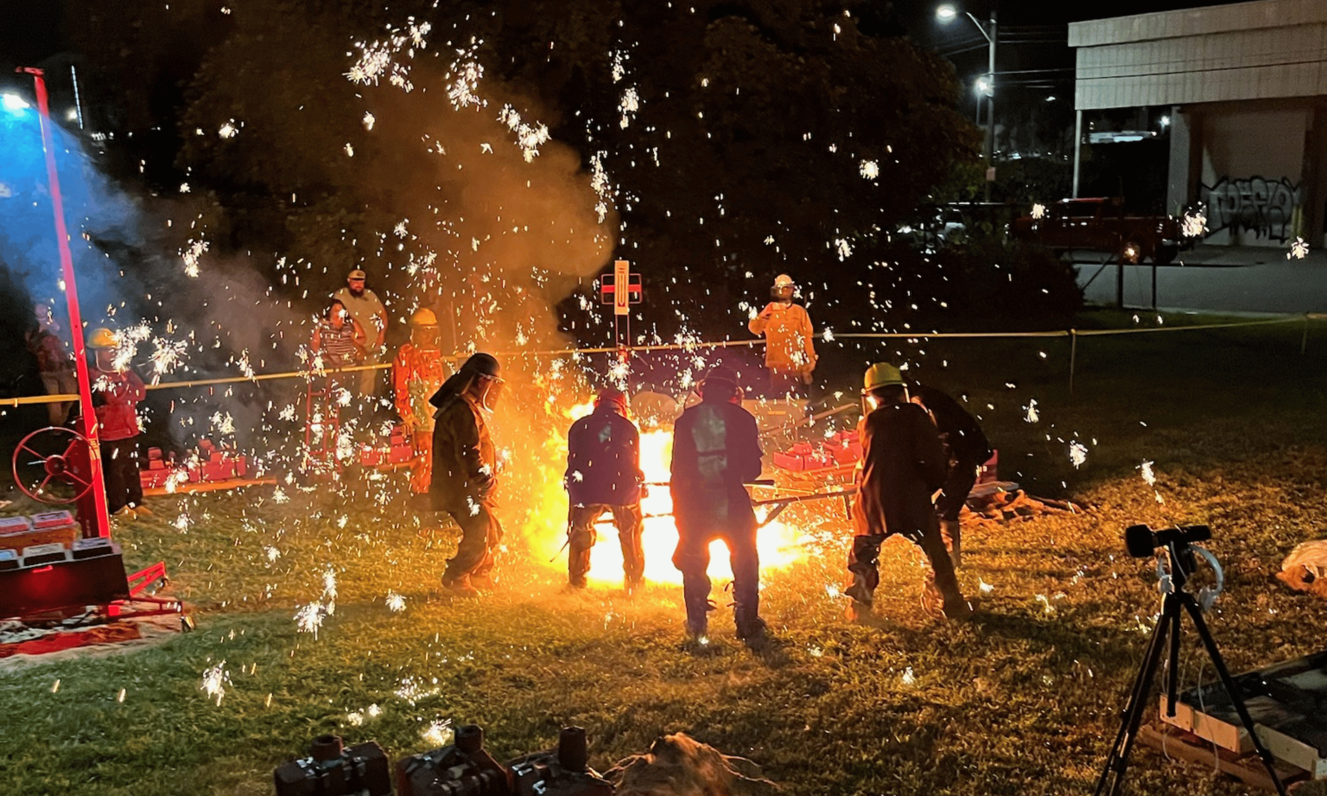 Metal workers pour iron around a raging fire at the "Arts on Fire" event at Mixxer Community Makerspace in Winston-Salem.