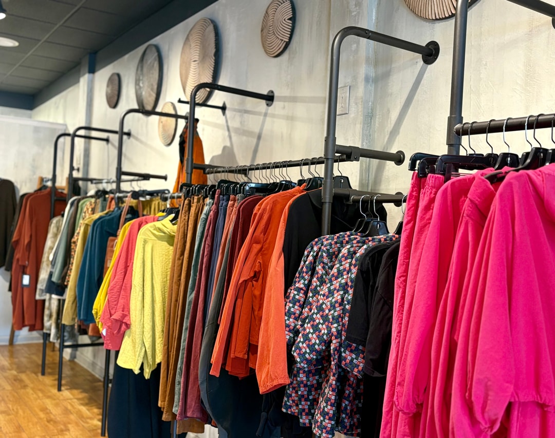 A wall of racks filled with colorful clothes at Gaia Boutique in Winston-Salem, North Carolina.