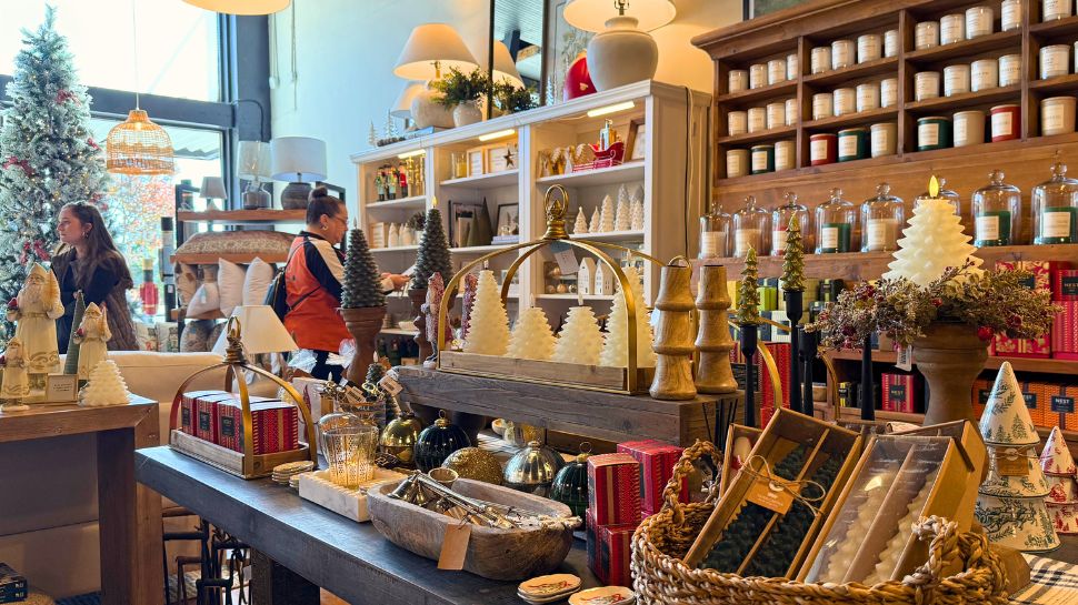 A store table display inside Blue Nest Mercantile & Design in Kernersville, showcasing gifts, candles, and seasonal home decor.