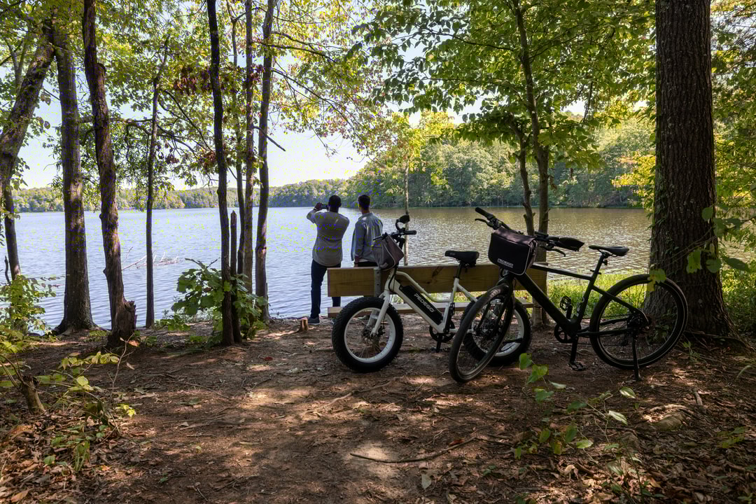 Two people stop with their bicycles at a lakeside overlook on the Salem Lake Trail in Winston-Salem.