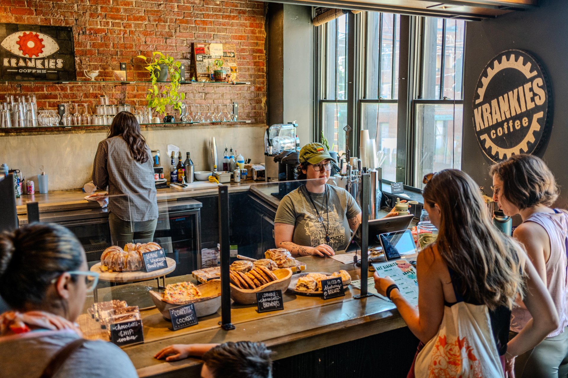A small group of people browses the breakfast and pastry case at Krankie's Coffee before placing an order.