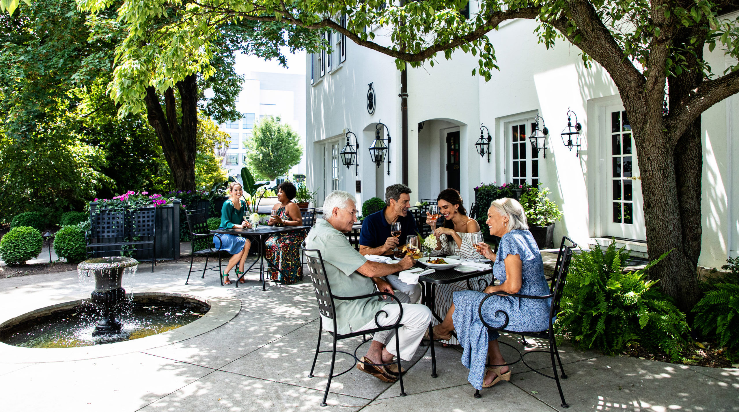 A group of people dine on the outdoor patio at Spring House Restaurant.