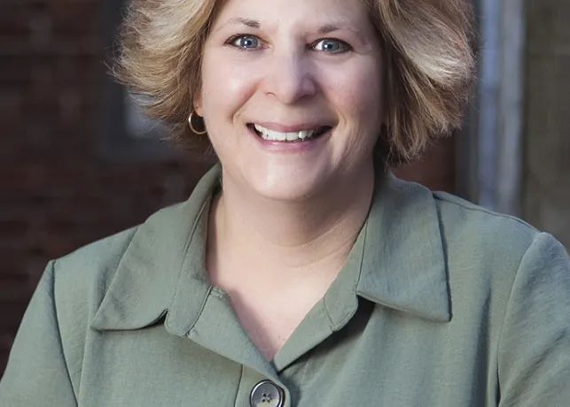 Headshot of blond woman in a green blazer