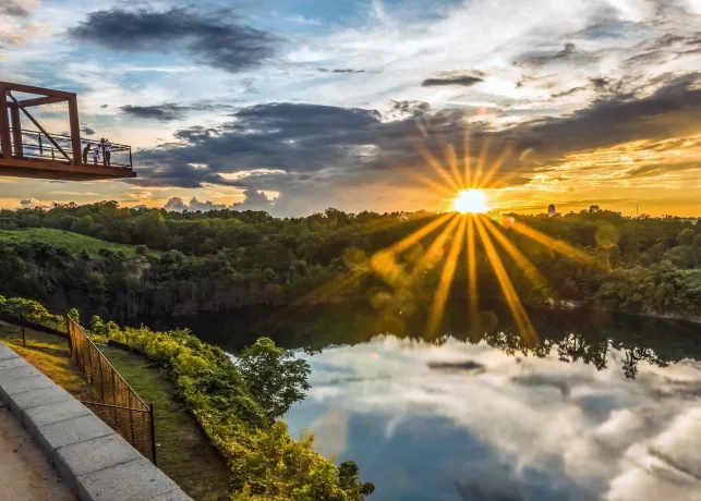 Wide angle shot of a rock quarry lake with an observation deck at sunset