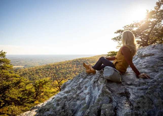 A woman sitting on an overlook at Hanging Rock State Park