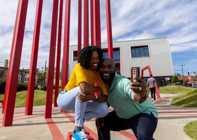 A couple poses in front of an art installation in downtown Winston-Salem