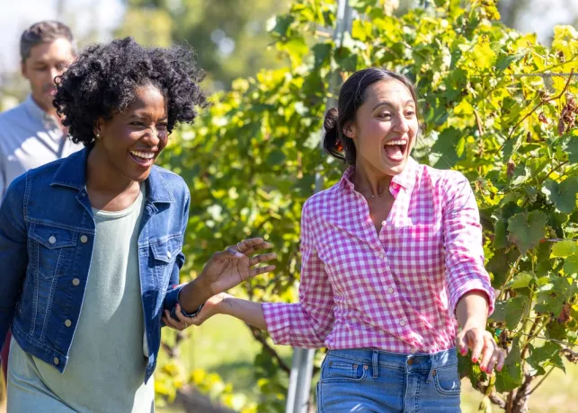 Two women exploring the vines at Jolo Winery & Vineyards.