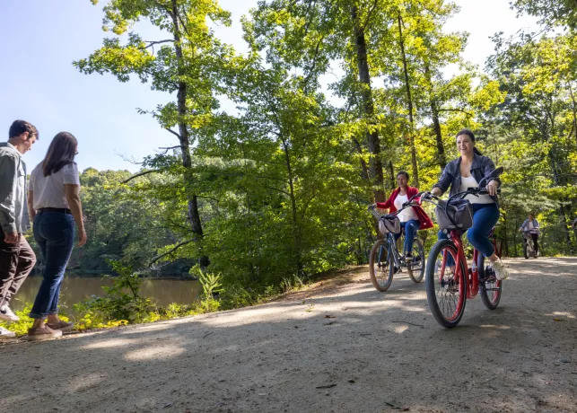 Two people walk while two other ride bikes along Salem Lake Trail in Winston-Salem.