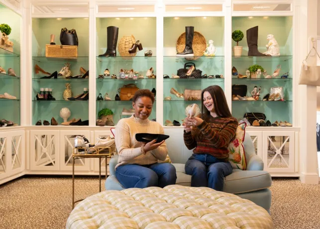 Two women admire shoes inside of Monkees of the Village Boutique in Reynolda Village Shopping Center.