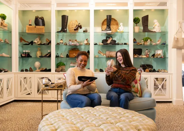 Two women admire shoes inside of Monkees of the Village Boutique in Reynolda Village Shopping Center.