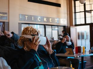 A woman adjusts her virtual reality headset at the Magnolia Shoebox Lunch and Learn: Traveling While Black experience in Winston-Salem.