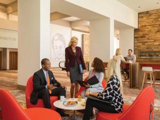 A group of meeting attendees discuss marketing and public relations options for meeting promotions