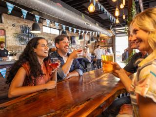 A male and female couple enjoy craft beers with friends at Wise Man Brewing in Winston-Salem.