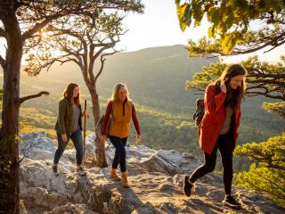 A group of three women hike to the summit of Hanging Rock State Park near Winston-Salem, North Carolina.