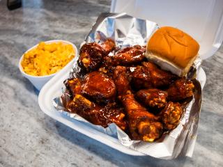 A plate of fried barbeque wings with a dinner roll at Goodness Gracious restaurant in Winston-Salem.