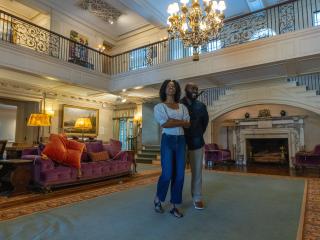 A male and female couple stand in the middle of the great room at Reynolda House Museum of American Art.