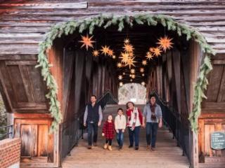 A family crosses the Heritage Bridge at Christmastime in Old Salem Museum & Gardens in Winston-Salem.