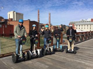 A group of visitors pose for a photo on segways during a tour of downtown Winston-Salem.