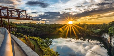 Wide angle shot of a rock quarry lake with an observation deck at sunset