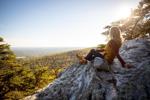A woman sitting on an overlook at Hanging Rock State Park