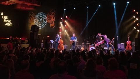 A band plays a live show on stage at The Ramkat