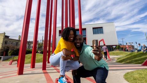 A couple poses in front of an art installation in downtown Winston-Salem