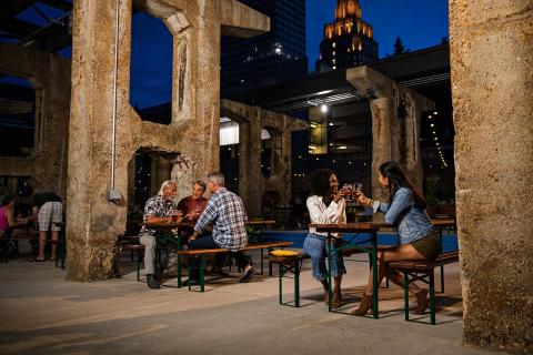 Two groups of people sit at separate picnic tables drinking pints of beer at Incendiary Brewing in Winston-Salem.