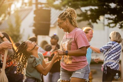 A mother and child dance together at the Summer Music Series in downtown Winston-Salem.