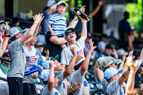 A young child catches a foul ball at a Winston-Salem Dash baseball game.