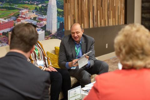A group of meeting planners sit together at a sitting area during a conference to discuss meetings and conventions in Winston-Salem.