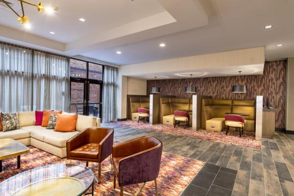 The lounge area offers guests additional seating with a TV, direct access to the Courtyard Patio, and close proximity to the Business Pods and Business Center. Photo 10