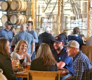 A group of patrons sits around a table at Fiddlin' Fish Brewery in Winston-Salem.