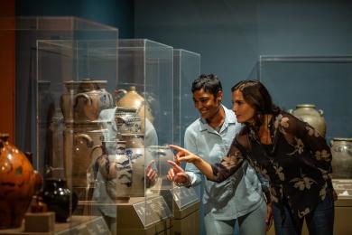 Two women looking at ceramic art in a museum