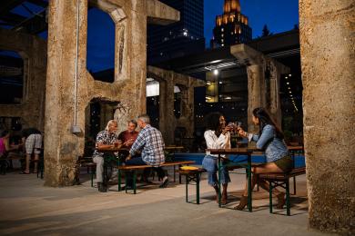 Two groups of people sit at separate picnic tables drinking pints of beer at Incendiary Brewing in Winston-Salem.
