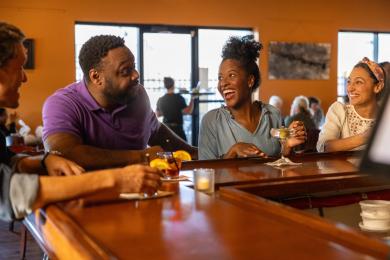 A group of men and women sit at the bar at a Winston-Salem restaurant.