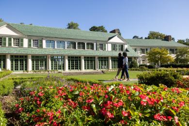 A man and woman tour the Reynolda grounds in front of the Reynolda House Museum of American Art.