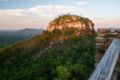 The sun sets at Pilot Mountain State Park, casting golden hour light on the Big Pinnacle.