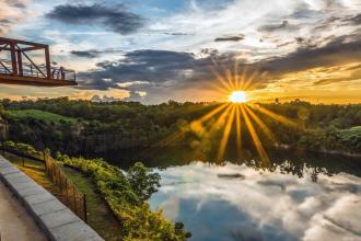 Wide angle shot of a rock quarry lake with an observation deck at sunset