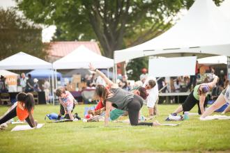 Group of people doing yoga on a grassy lawn