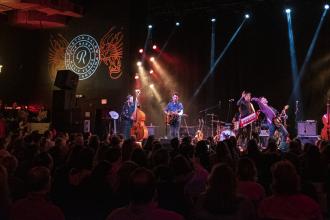 A band plays a live show on stage at The Ramkat