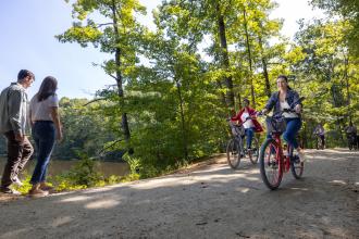 Two people walk while two other ride bikes along Salem Lake Trail in Winston-Salem.