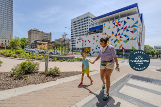 A woman and child walk in Merschel Park, outside of Kaleideum Children's Museum in downtown Winston-Salem.